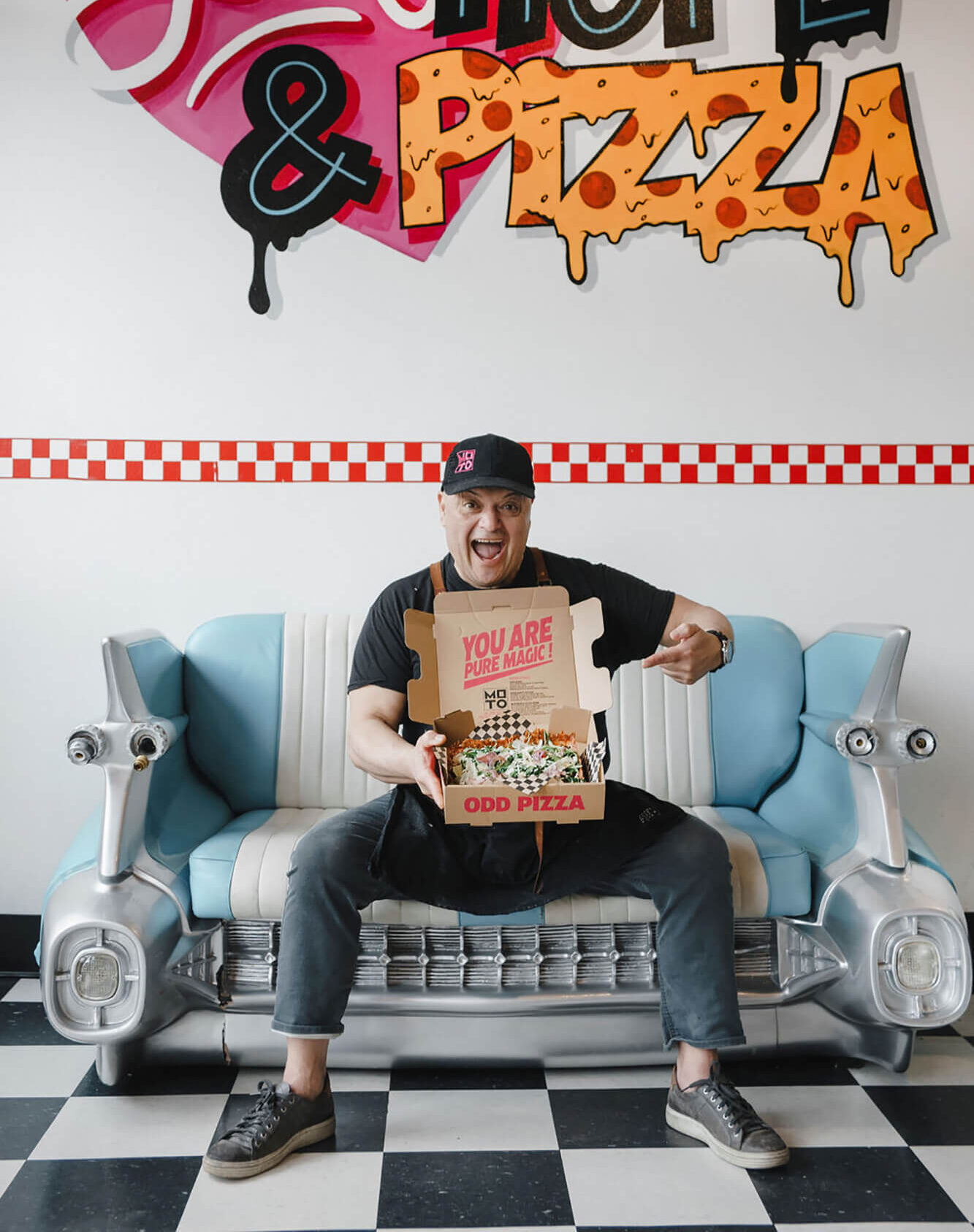 Lee Sitting on Couch Holding a Box of Pizza